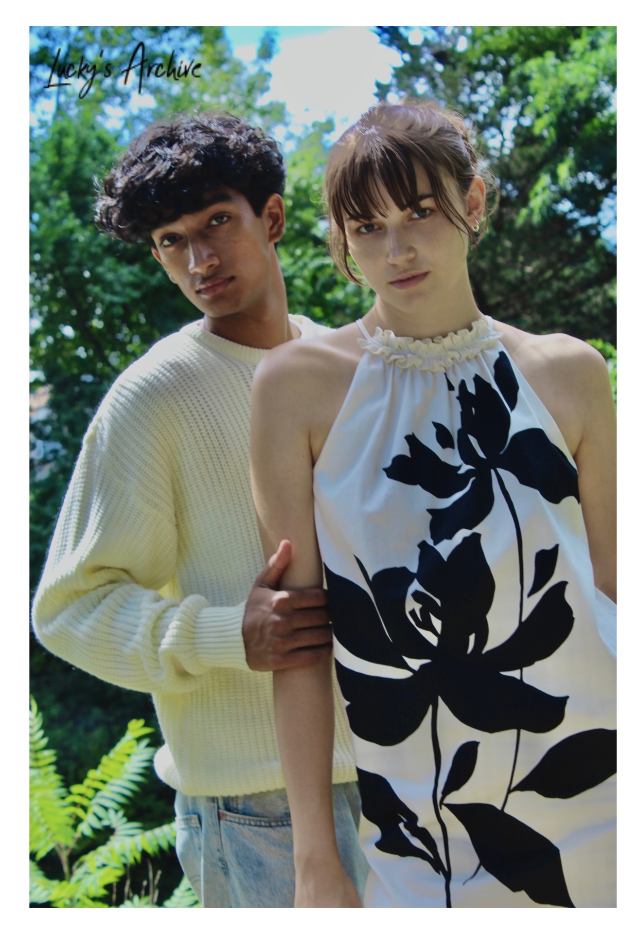 Couple portrait with arm linked under green trees