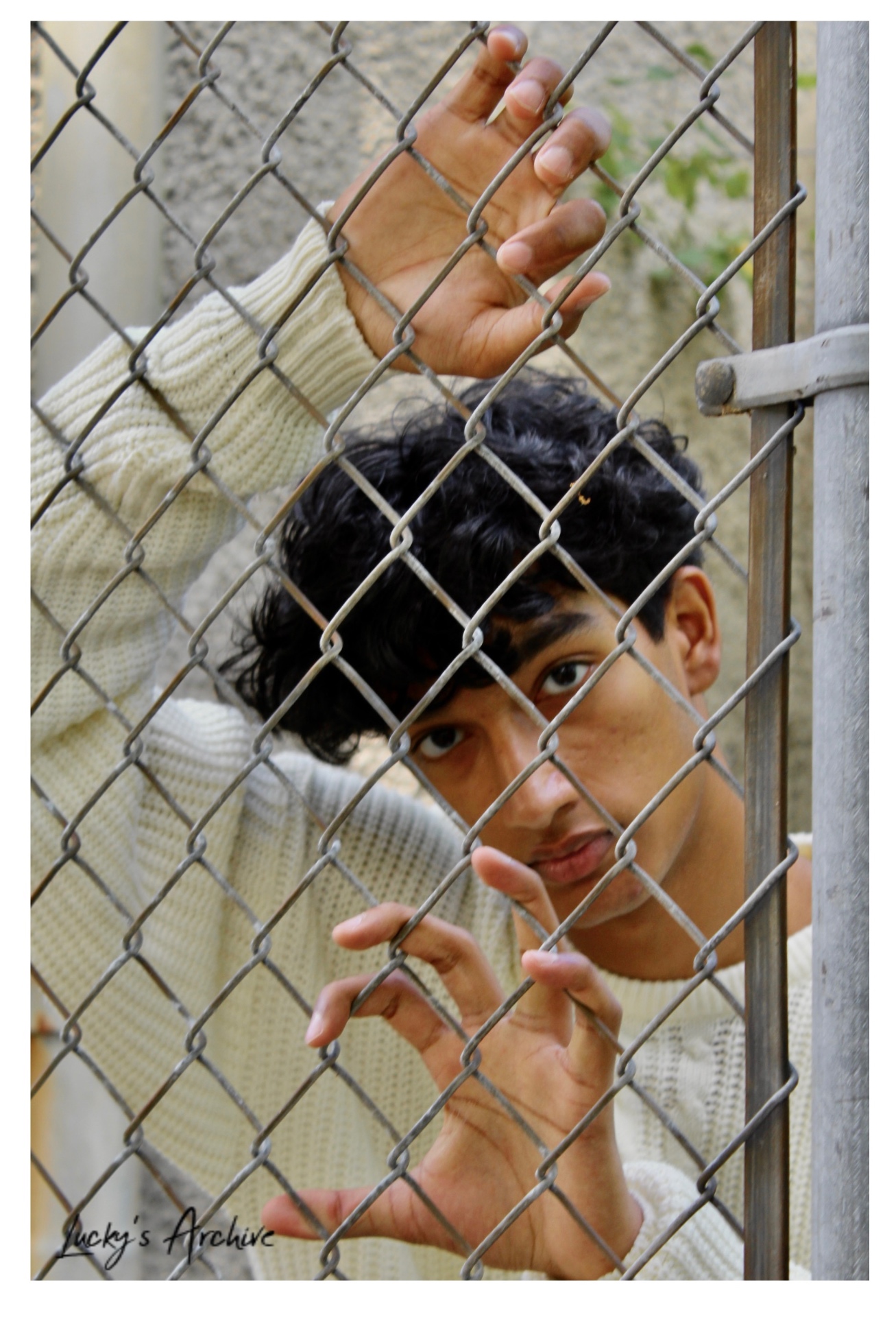 Creative portrait through a chain-link fence