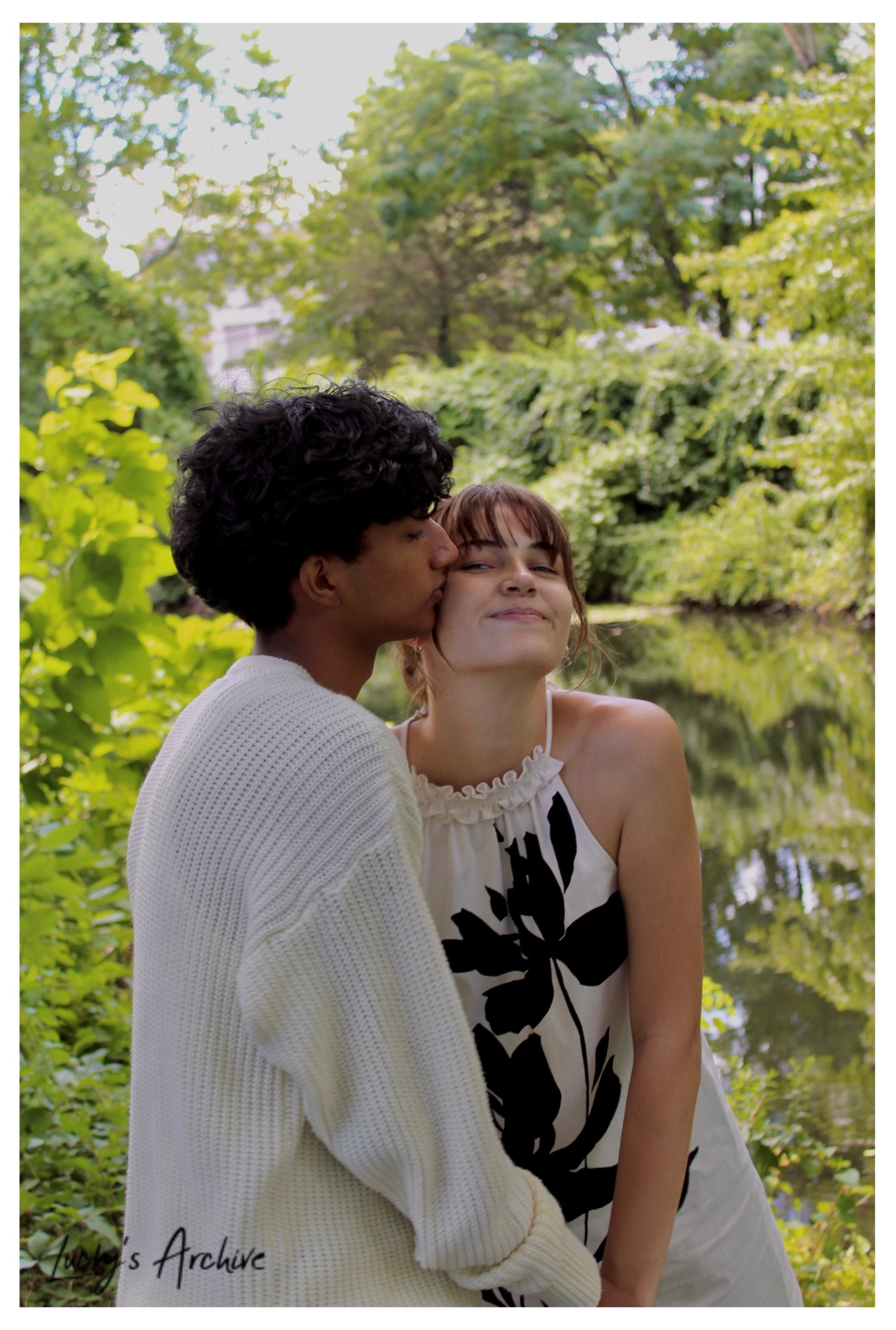 Kiss on the cheek beside a pond