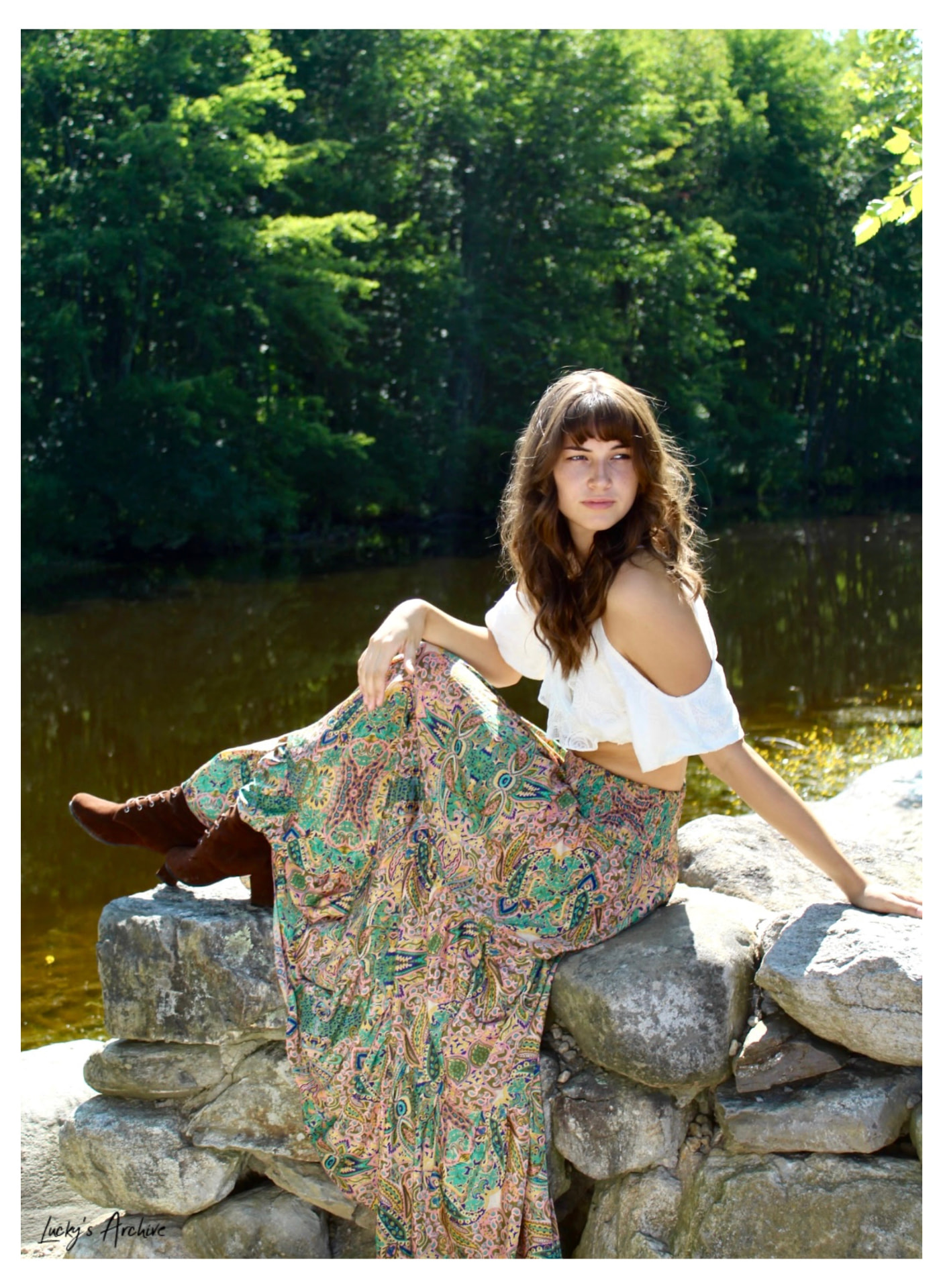 Editorial portrait on riverside rocks