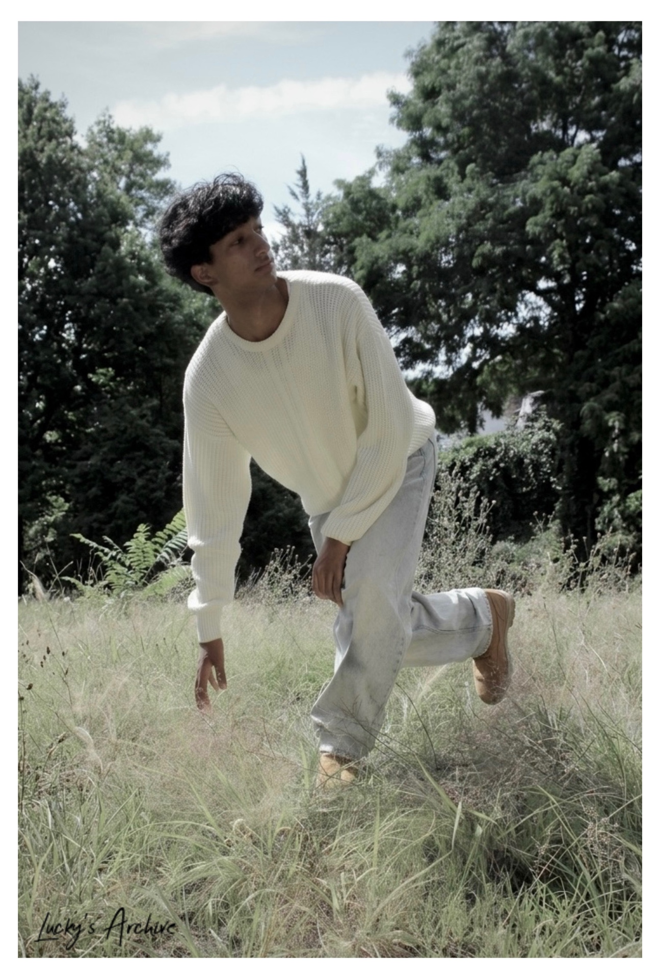 Movement portrait in a cream knit sweater in a summer field