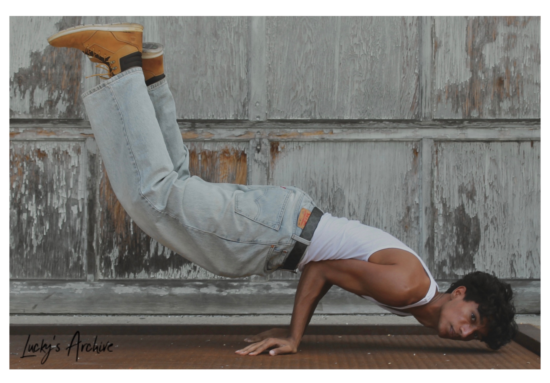 Dynamic floor pose in a white tank and denim