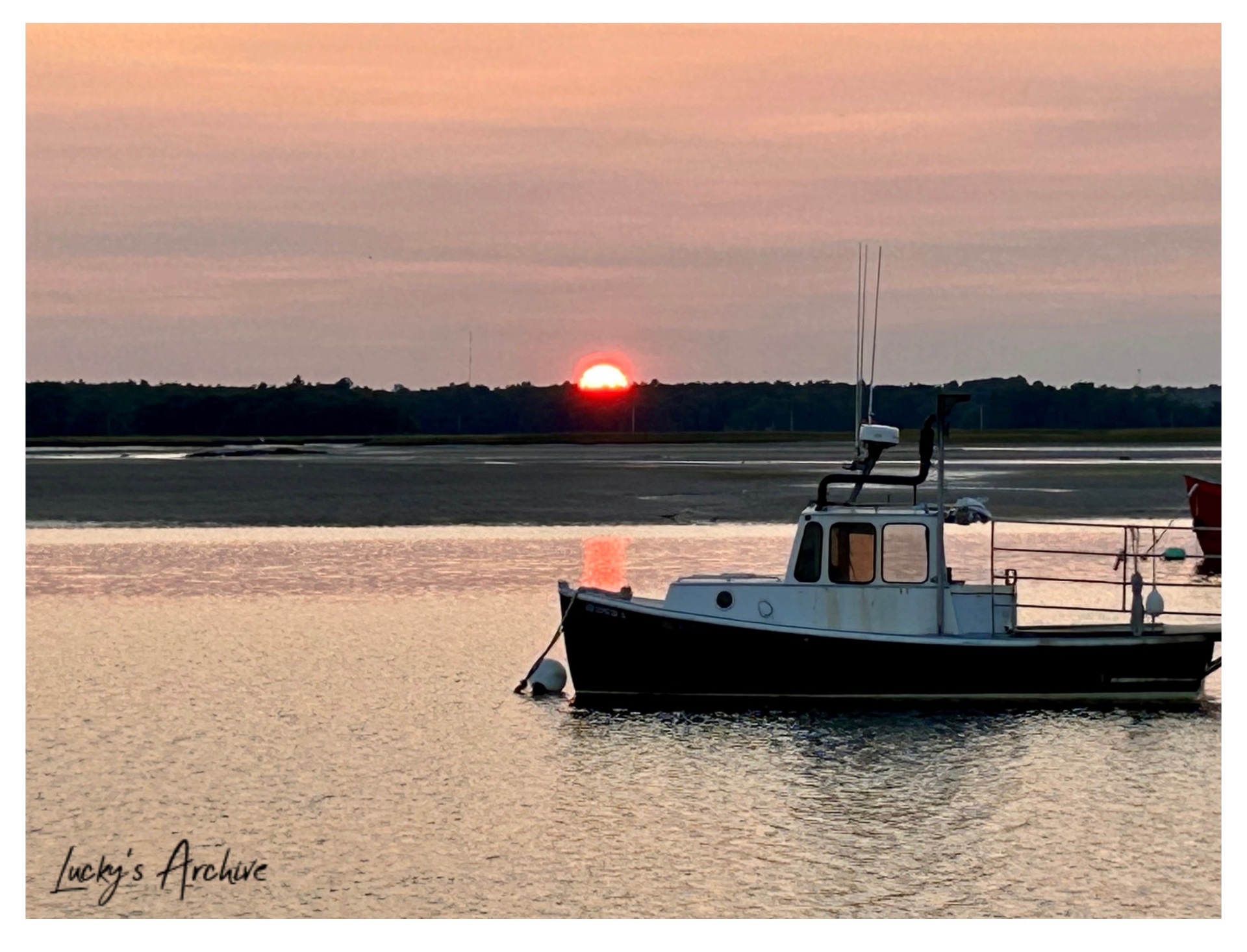 Fishing boat moored in a tidal harbor at sunset
